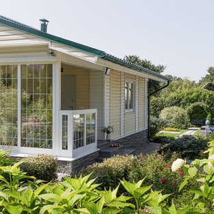 Exempel på ett modernt gult hus, med tak i metall