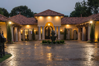 This is an example of a large mediterranean one-storey stucco beige exterior in Oklahoma City with a hip roof.