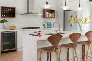 Inspiration for a mid-sized modern galley light wood floor eat-in kitchen remodel in Toronto with an undermount sink, flat-panel cabinets, white cabinets, marble countertops, white backsplash, marble backsplash, stainless steel appliances, an island and white countertops