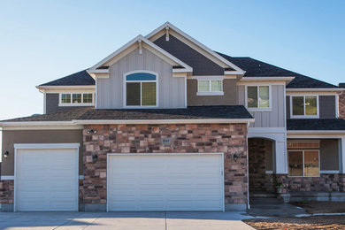 Inspiration for a large craftsman gray two-story stone exterior home remodel in Salt Lake City with a clipped gable roof