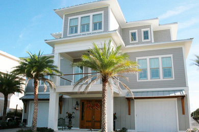 Example of a gray three-story wood house exterior design in Other with a metal roof