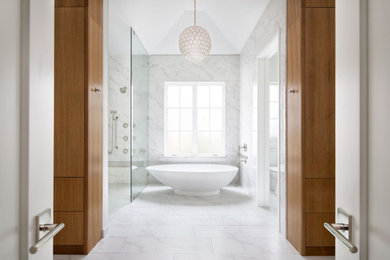 This is an example of a mid-sized contemporary master bathroom in Austin with flat-panel cabinets, white cabinets, a curbless shower, a two-piece toilet, white tile, porcelain tile, white walls, ceramic floors, an undermount sink, solid surface benchtops, white floor, a hinged shower door, white benchtops, a shower seat, a built-in vanity, timber, planked wall panelling and a double vanity.
