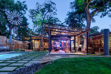 Small urban backyard concrete paver patio photo in Dallas with a roof extension