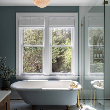 Clawfoot tub beneath restored double-hung windows