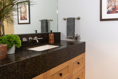 Example of a mid-sized minimalist 3/4 beige tile and ceramic tile ceramic tile, gray floor and single-sink bathroom design in Los Angeles with shaker cabinets, light wood cabinets, a one-piece toilet, beige walls, an undermount sink, granite countertops, black countertops, a niche and a floating vanity