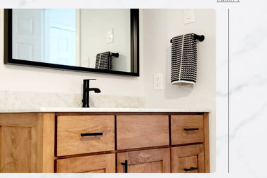 Small 1950s master black and white tile and ceramic tile vinyl floor, gray floor and single-sink alcove shower photo in Toronto with raised-panel cabinets, light wood cabinets, a one-piece toilet, gray walls, a drop-in sink, quartzite countertops, a hinged shower door, a niche and a freestanding vanity