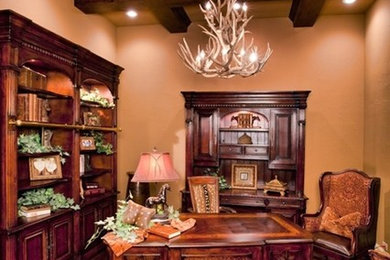 Example of a large freestanding desk dark wood floor study room design in Austin with beige walls