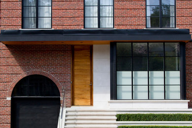 Photo of a mid-sized contemporary two-storey brick red house exterior in Toronto.