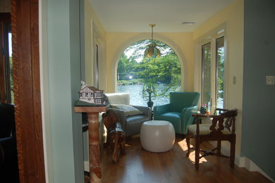 Inspiration for a mid-sized craftsman enclosed medium tone wood floor living room library remodel in New York with yellow walls