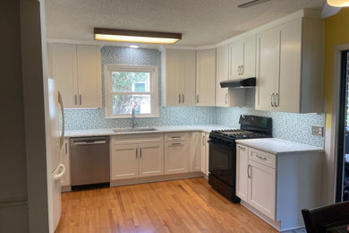 Example of a mid-sized transitional u-shaped kitchen pantry design in Charleston with shaker cabinets, white cabinets and quartz countertops