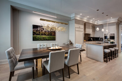 Mid-sized transitional kitchen/dining combo in Toronto with beige walls, light hardwood floors and grey floor.