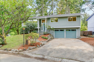 Example of a mid-sized mid-century modern gray two-story concrete fiberboard exterior home design in Seattle with a shingle roof