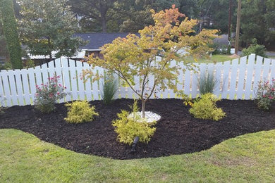 This is an example of a mid-sized traditional partial sun front yard mulch landscaping in Atlanta for summer.