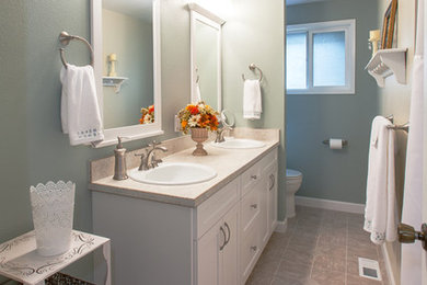 Inspiration for a contemporary tub/shower combo remodel in Boise with a drop-in sink, recessed-panel cabinets, white cabinets, laminate countertops and a one-piece toilet
