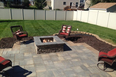 Example of a mid-sized mountain style backyard stone patio design in Other with a fire pit and no cover