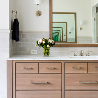 Cette image montre une salle de bain principale traditionnelle de taille moyenne avec un placard à porte affleurante, des portes de placard en bois clair, une baignoire indépendante, une douche d'angle, un WC séparé, un carrelage gris, des carreaux de céramique, un mur blanc, un sol en marbre, un lavabo encastré et un plan de toilette en marbre.