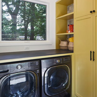 Photo of a medium sized classic l-shaped separated utility room in Austin with shaker cabinets, yellow cabinets, white walls, a side by side washer and dryer and grey worktops.