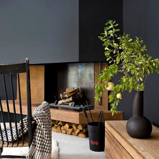 Exempel på ett mellanstort modernt allrum med öppen planlösning, med svarta väggar, betonggolv och en standard öppen spis