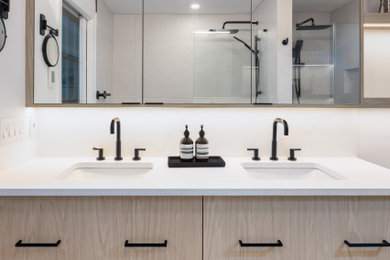 This is an example of a small contemporary wet room bathroom in Vancouver with flat-panel cabinets, light wood cabinets, a one-piece toilet, white tile, porcelain tile, white walls, porcelain floors, an undermount sink, engineered quartz benchtops, blue floor, a hinged shower door, white benchtops, a niche, a single vanity and a built-in vanity.
