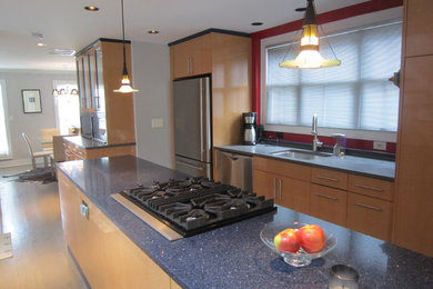 Small minimalist single-wall light wood floor and beige floor enclosed kitchen photo in Baltimore with an undermount sink, flat-panel cabinets, light wood cabinets, limestone countertops, stainless steel appliances and an island
