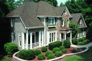 Large trendy gray two-story wood exterior home photo in Oklahoma City with a hip roof