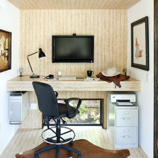 Medium sized modern home office and library in Austin with a built-in desk and beige walls.