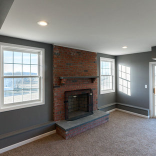This is an example of a large classic walk-out basement in San Diego with grey walls, carpet, a standard fireplace, a brick fireplace surround and beige floors.
