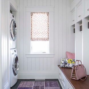 Foto de lavadero multiusos y de galera, clásico renovado, de tamaño medio, con puertas de armario blancas, encimera de madera, paredes blancas, lavadora y secadora apiladas, fregadero bajoencimera, armarios con paneles empotrados, suelo de pizarra y suelo gris