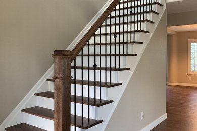 Diseño de escalera recta clásica grande con escalones de madera, contrahuellas de madera pintada y barandilla de varios materiales
