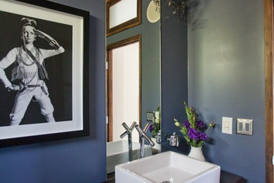 Inspiration for a mid-sized contemporary 3/4 bathroom remodel in Los Angeles with purple walls, a drop-in sink, open cabinets, medium tone wood cabinets and wood countertops