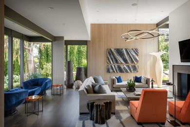 Family room - contemporary dark wood floor and brown floor family room idea in Seattle with white walls, a standard fireplace and a wall-mounted tv