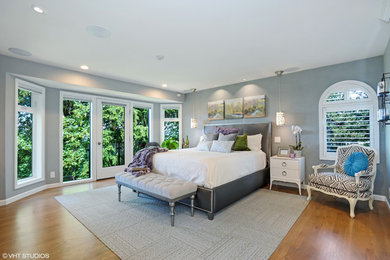 Photo of a large transitional master bedroom in Seattle with grey walls and medium hardwood floors.