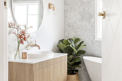 Inspiration for a large contemporary master bathroom in Melbourne with medium wood cabinets, a freestanding tub, white tile, porcelain tile, porcelain floors, grey floor and white benchtops.