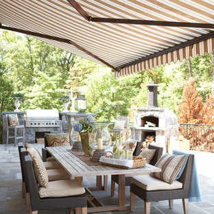 Großer Klassischer Patio hinter dem Haus mit Outdoor-Küche, Betonplatten und Markisen in New York