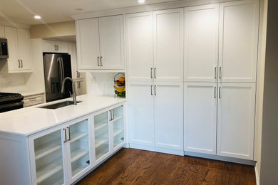 Kitchen - kitchen idea in Chicago with shaker cabinets, white cabinets, stainless steel appliances and an island