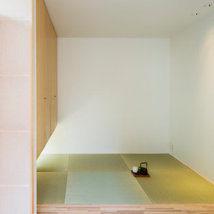 Immagine di un soggiorno minimalista con pareti bianche, pavimento in tatami e nessuna TV