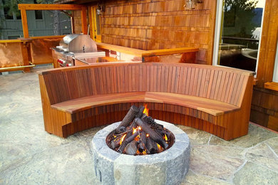 Example of a mid-sized mountain style backyard stone patio design in Denver with a fire pit and no cover