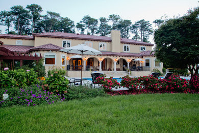Example of a huge tuscan beige two-story stucco exterior home design in Other with a hip roof