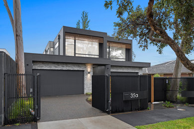 Photo of a large contemporary two-storey brick grey duplex exterior in Melbourne with a flat roof.