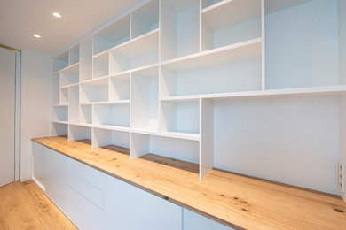 Geräumiges Modernes Arbeitszimmer mit Arbeitsplatz, weißer Wandfarbe und braunem Holzboden in Frankfurt am Main