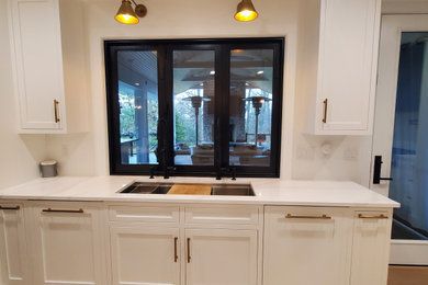 Large transitional u-shaped light wood floor eat-in kitchen photo in Cincinnati with an undermount sink, shaker cabinets, light wood cabinets, quartz countertops, white backsplash, quartz backsplash, paneled appliances, an island and white countertops