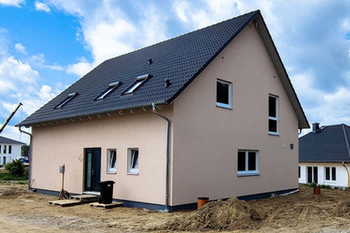 Mittelgroßes, Einstöckiges Klassisches Einfamilienhaus mit Putzfassade, beiger Fassadenfarbe, Satteldach, Ziegeldach und grauem Dach in Sonstige