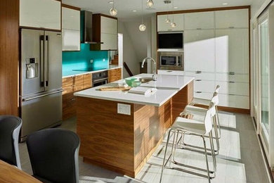 This is an example of a large midcentury l-shaped eat-in kitchen in Calgary with a double-bowl sink, flat-panel cabinets, white cabinets, quartz benchtops, blue splashback, porcelain splashback, stainless steel appliances, porcelain floors and with island.