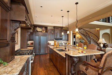 Mid-sized tuscan l-shaped medium tone wood floor open concept kitchen photo in Vancouver with an undermount sink, granite countertops, an island, recessed-panel cabinets, medium tone wood cabinets, beige backsplash, ceramic backsplash and paneled appliances