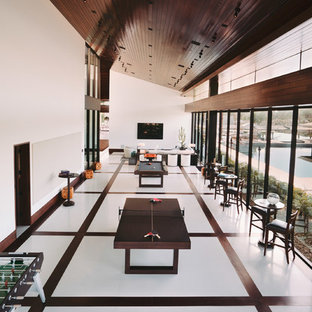 Exemple d'une très grande salle de cinéma moderne ouverte avec un mur blanc, un sol en marbre, un téléviseur fixé au mur et un sol blanc.