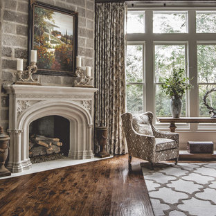 Mediterranean formal enclosed living room in Dallas with white walls, medium hardwood flooring, a standard fireplace, a plastered fireplace surround and no tv.