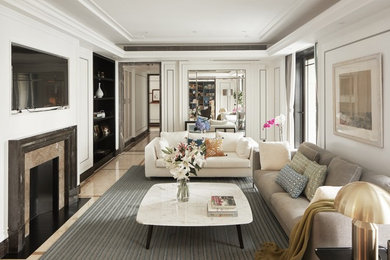 This is an example of a traditional living room in Other with white walls, a standard fireplace, a wall mounted tv and beige floors.