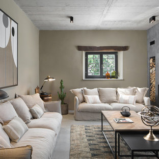 Foto di un soggiorno mediterraneo con pareti beige, pavimento in cemento, camino classico e pavimento grigio