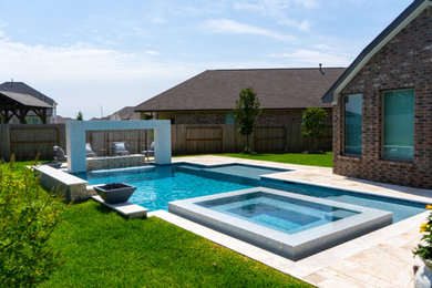 Mid-sized minimalist backyard stone and rectangular hot tub photo in Houston