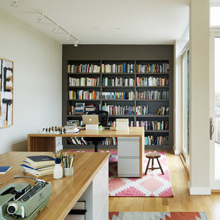 Inspiration for a small modern home studio in Chicago with beige walls, light hardwood flooring, no fireplace and a freestanding desk.